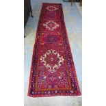 Eastern runner, red field with five medallions and flowerhead borders, 350 x 85cm