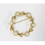 14ct gold pearl brooch, circular with six pearl flowerheads interspersed with leaves, stamped 14k,