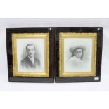 A pair of glazed showcase frames containing a male and female monochrome portrait plaques within
