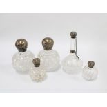 A collection of late 19th and early 20th century silver mounted glass scent bottles, tallest 16cm (