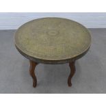 Benares style table with circular engraved brass top, 50 x 60cm.