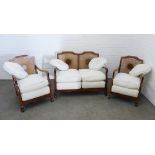 Walnut and bergere suite comprising a two seater settee and pair of armchairs with loose squab and