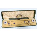 Edwardian gilt metal and purple enamel dress set comprising two mother of pearl hatpins, a buckle,