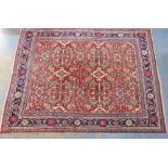 Large Persian carpet, the red field with an allover foliate pattern with geometric and flowerhead