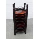 Set of thirteen chinoiserie wooden plates in a stacking stand, 66 x 26cm.