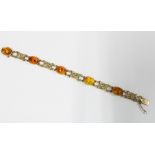 9ct gold bracelet with five amber cabochons interspersed with gold flowerhead panels, full set of