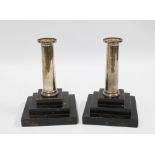 A pair of silver candlesticks on stepped ebonised wood bases, 18cm high overall, (2)