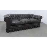 Worn brown leather chesterfield sofa, typical design with pleated skirt, 60 x 206 x 59cm.