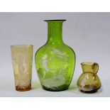 Mary Gregory glass to include a green vase, small green jug and a an amber coloured beaker (3) 17cm