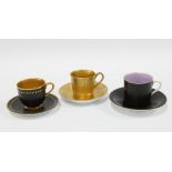 Two Royal worcester black glazed demitasse cups and saucers together with a Royal Doulton gilt