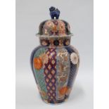 Imari covered baluster vase, typically painted with chrysanthemums and foliage, the cover with a