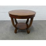 An art deco occasional two tier table with a circular veneered top and stylised legs 46 x 59cm.