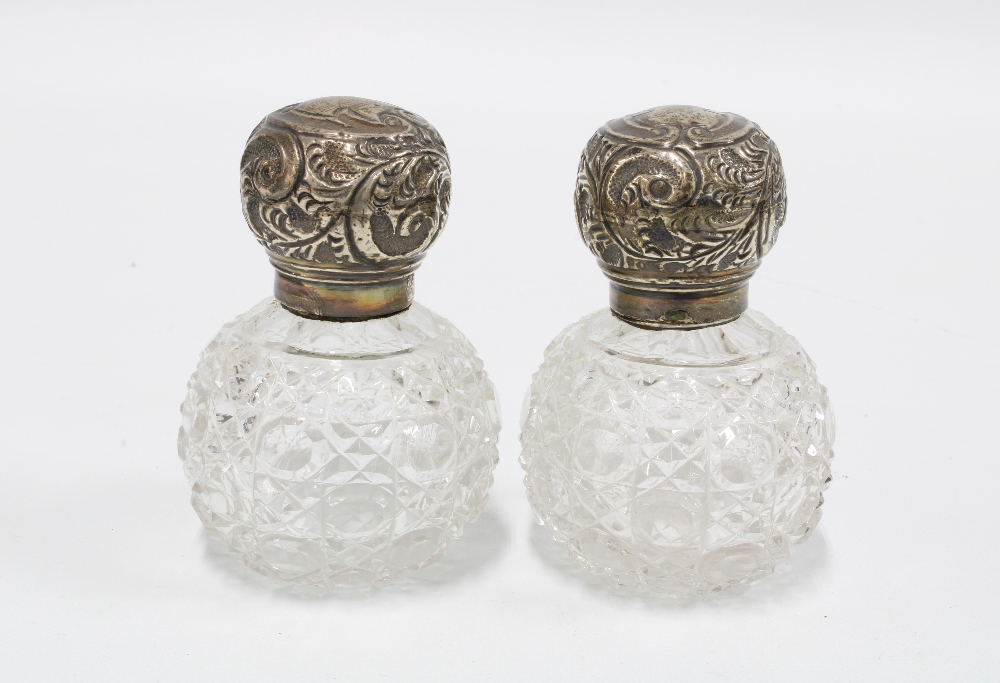 A pair of silver top glass scent bottles, London 1915, 7cm high (2)