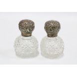A pair of silver top glass scent bottles, London 1915, 7cm high (2)