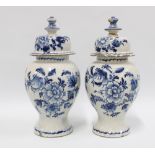 A pair of delft blue and white lidded vases with mixed flowers and wavy bottom border, (2) (some