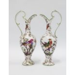 A pair of continental porcelain ewer shaped vases with green rims and shaped handles, white ground