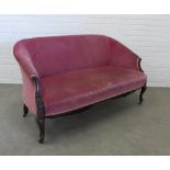 Late 19th century mahogany framed two seater settee, with scroll arms and leaf carved legs, pale red
