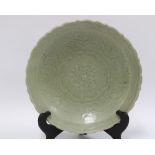 Chinese Qingbai dish / shallow bowl, the celadon ground with carved lotus pattern, wavy edged rim,