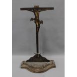 Floor standing, painted metal crucifix on a serpentine wooden base, 63cm high