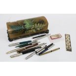 Victorian lacquered glove box containing a collection of vintage ballpoint pens and a Dickens