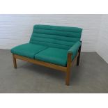 Mid century two seater settee, upholstered in green wool mix fabric with a single end arm and teak