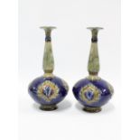 A pair of Royal Doulton stoneware bottle vases, blue ground with Art Nouveau floral patterns, with
