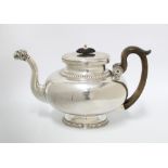 White metal teapot of oval outline, possibly French, with a fluted border to the neck and footrim,