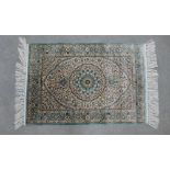 An Isfahan style silk rug with an ivory field and allover foliate pattern, two fringed ends, 95 x