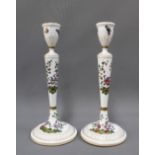 A pair of porcelain candlesticks, handpainted with fancy bird patterns, with gilt edged sconces