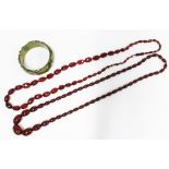 A vintage strand of faux cherry amber beads, a green bangle and a strand of faceted beads, (3)