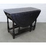 Dark oak gate leg table with carved top. 75 x 128 x 106cm.