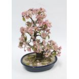 Hardstone plant with pink flowers and green leaves, in a blue ceramic planter, 33cm.