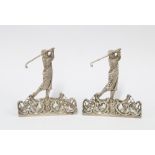 A pair of silver menu card holders by William Comyns, London 1901, each with a golfer in full swing,