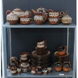 A quantity of Romanian or eastern european brown glazed pottery to include tea sets, miniature vases