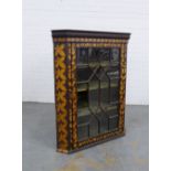 A late 19th / early 20th century pokerwork glazed corner cabinet opening to reveal a green velvet