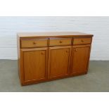 Teak sideboard, three short drawers and three panelled doors, 77 x 124 x 45cm.