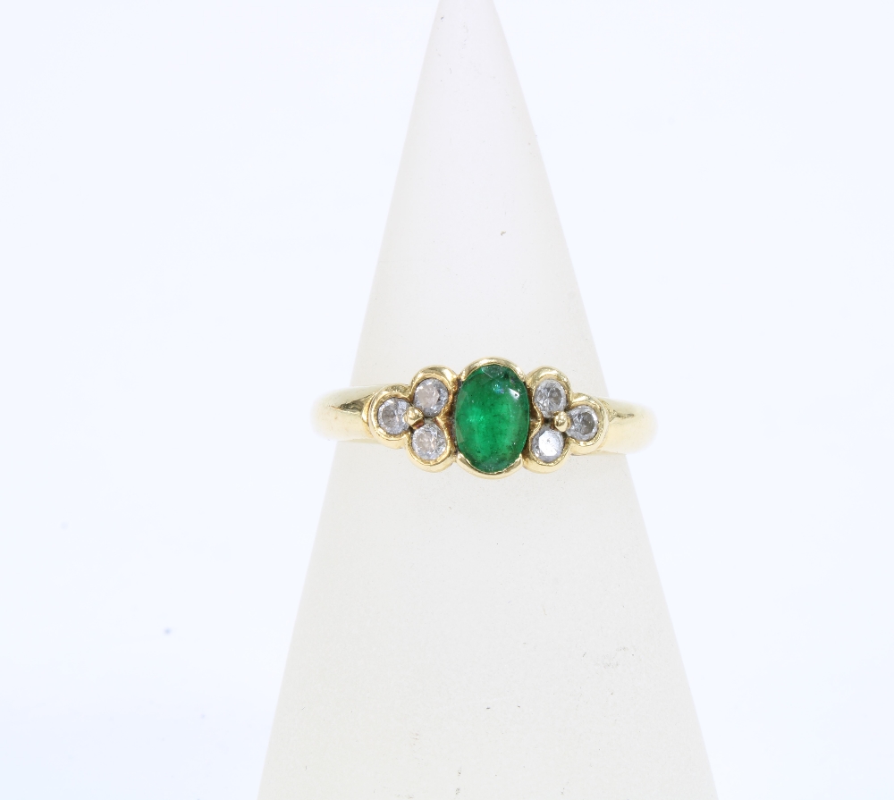 18ct gold emerald & diamond dress ring, with an oval emerald flanked by three bright cut diamonds,