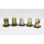 Set of five Japanese jars with covers and saucers, in various botanical patterns, 12cm (5)