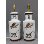 A pair of of chinoiserie table lamp bases, white glazed and decorated with monkeys, 43cm (2)