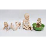 Four bisque piano babies to include Gebruder Heubach, one in a green bowl, tallest 16cm (4)