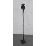 An African staff with figure head, on square plinth base, 135cm.