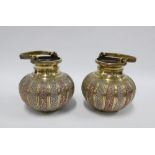 A pair of brass bowls with swing handles and mixed metal pattern in relief, 16cm high excluding