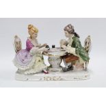 Continental porcelain figure group of a a man and woman playing backgammon, 26cm long