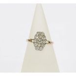 Diamond dress ring, the central claw set diamond within a surround of twelve smaller diamonds, set