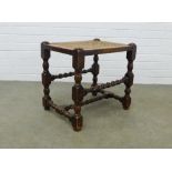 Dark elm stool with cane work seat, on block and bobbin legs with barley twist supports, 51 x 48 x