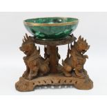 Malachite bowl, 21cm diameter, on a chinoiserie carved wooden stand supported by three foo dogs,