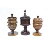 Two large treen tobacco jars of goblet form compete with covers together with a large treen