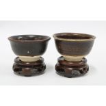 Two Chinese brown glazed tea bowls, possibly Yuan Dynasty, 7cm diameter, with wooden stands (2)
