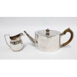 Georgian white metal teapot and a silver cream jug, London 1807 (2)