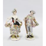 Two porcelain male and female flower seller figures, the girl with a blue anchor mark and the boy